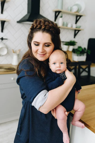 Relajado encantadora madre y bebé abrazándose en la cocina — Foto de Stock