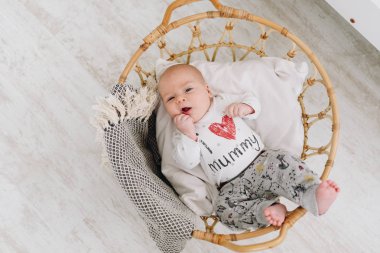 Küçük beyaz bir bebek yukarıdan aşağıya bir sepet içinde yatıyordu