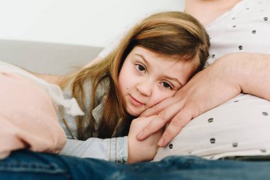 Babasına yaslanıp sarılarak rahat bir kızın portresi