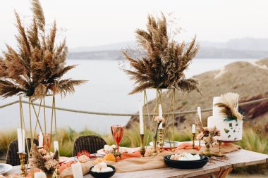 Adada güzel bir düğün için turuncu, kırmızı ve altın rengi bir masa.