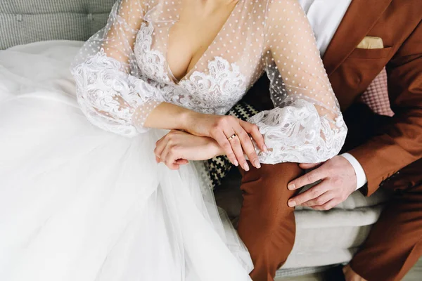 Primo piano di giovani sposi caucasici seduti insieme il giorno del loro matrimonio, sposa in bellissimo abito e sposo in abito marrone, sposato, felice e romantico — Foto Stock