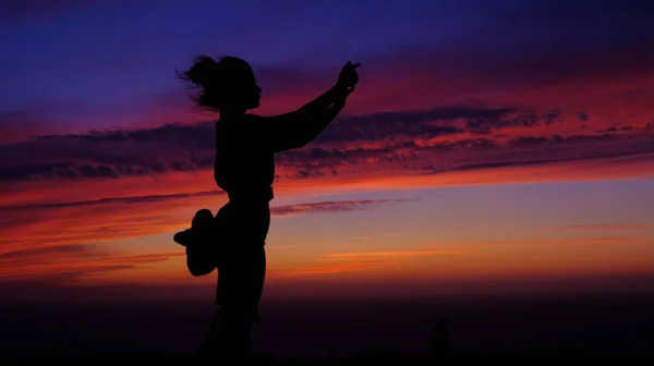 Kız gün batımında selfie çekiyor. Kızın siluetleri. Genç, güzel, kız gün batımı arka planda kendini fotoğraf. Deniz yürüyüşü. Seyahat, dünyanın ucunda fotoğraf. Portekiz'de gün batımı. C