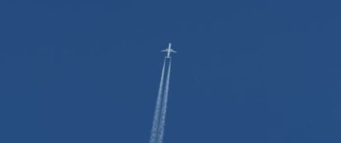 mavi gökyüzüne karşı uçak ve inversiyon yollar