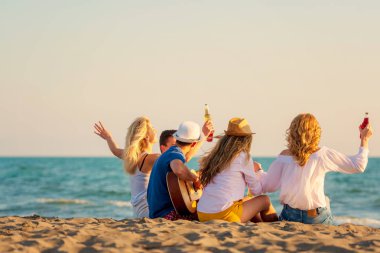 Bir grup arkadaş sahilde eğleniyor.
