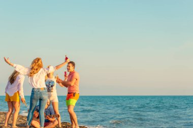 Bir grup arkadaş sahilde eğleniyor.