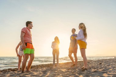 Bir grup arkadaş sahilde eğleniyor.