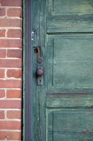 赤レンガの壁に古い木製の緑のドア — ストック写真
