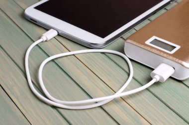 Taşınabilir güç banka ve tablet Pc ahşap arka plan üzerinde. Yakın çekim