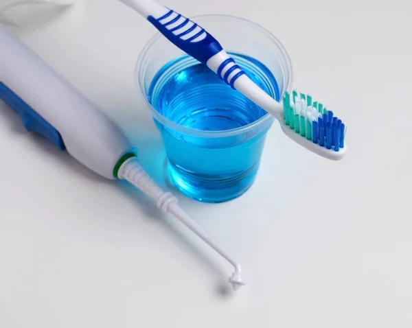 Diş sözlü irrigator, diş fırçası, diş macunu. Beyaz bir arka plan üzerinde. Yakın çekim