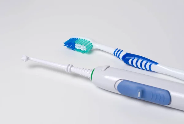 Dental hygiene. Toothbrush, oral irrigator on a white background — Stock Photo, Image