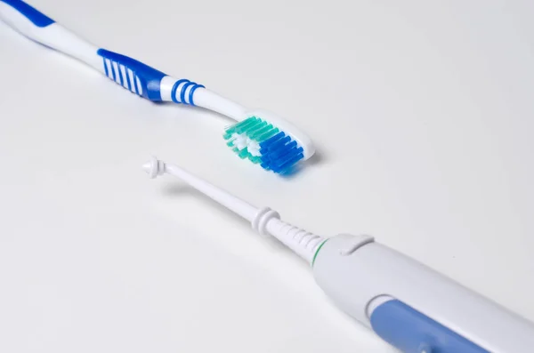 Igiene dentale. Spazzolino da denti, irrigatore orale su fondo bianco — Foto Stock