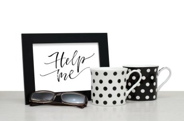 Yardım et. El yazısı yazıt çerçeve içinde. Modern hat. Kahve fincanı, gözlük. Yakın çekim