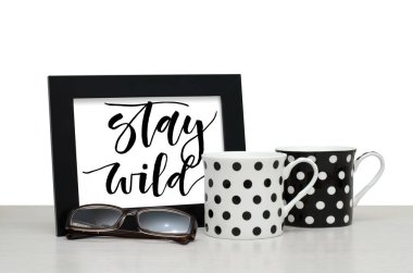 Vahşi kal. El yazısı yazıt çerçeve içinde. Modern hat. Kahve fincanı, gözlük. Yakın çekim