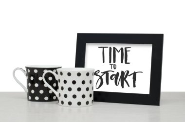 Başlama zamanı. El yazısı metin. Modern hat. Siyah ahşap çerçeve metin için. Siyah ve beyaz kahve Kupası tablo. Yakın çekim, beyaz arka plan