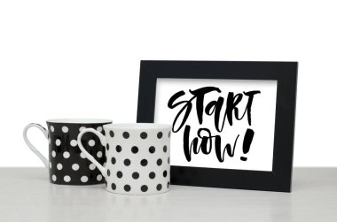 Şimdi tam zamanı. El yazısı metnini, ilham alıntı olduğunu. Modern hat. Siyah ahşap çerçeve. Siyah ve beyaz kahve Kupası tablo. Yakın çekim, beyaz arka plan