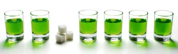 Відсутній зелений лікер в окулярах. Алкогольні галюциногенні напої. Білий фон. Шматочки білого цукру . — стокове фото