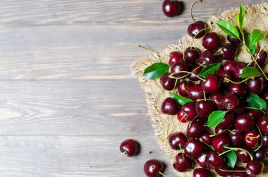 Eski kumaşta kiraz. Taze mahsul. Rustik tarz. Ahşap arka plan. Düz döşeme, kopyalama alanı