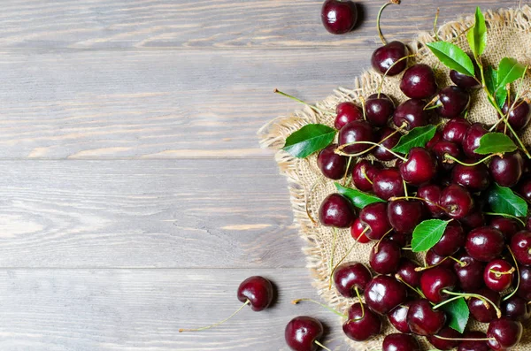 Eski kumaşta kiraz. Taze mahsul. Rustik tarz. Ahşap arka plan. Düz döşeme, kopyalama alanı