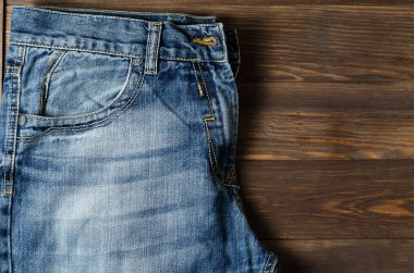 Denim. Kahverengi ahşap arka plan üzerinde mavi kot.