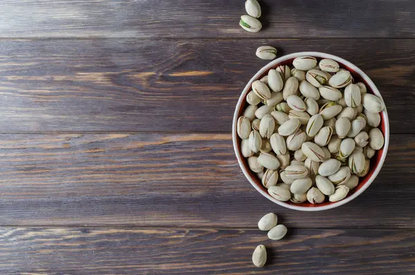 Tabakta antep fıstığı. Koyu ahşap arka plan