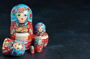 Beş kırmızı matryoshka. Geleneksel Rus oyuncağı. Uzayı kopyala Siyah beton arkaplan.