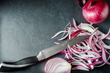 Tahta kesme tahtasında kırmızı soğan ve dilimlenmiş soğan. Yan görüş. Düz bir manzara. Boşluğu kopyala