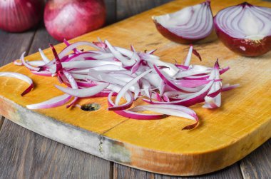 Kırmızı soğan dilimlenmiş. Sarı kesim tahtasında pişirme işlemi.