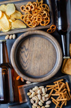 Bira şişelerinde bira ve bira için tuzlu atıştırmalıklar. Gri beton arka plan. Arkadaşlar için bir parti konsepti. Boşluğu kopyala