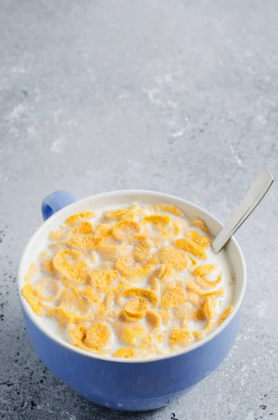 Majsflingor i mjölk. Blå bägaren. Friska och näringsrik frukost för ett barn. Kopiera utrymme. — Stockfoto