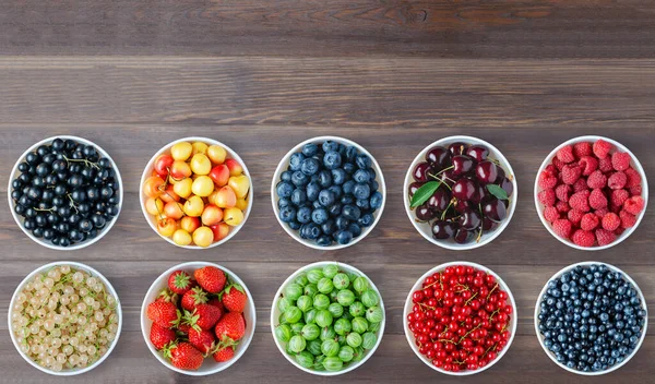 Yuvarlak tabakta bir çift böğürtlen. Kahverengi ahşap arka plan. Boşluğu kopyala.
