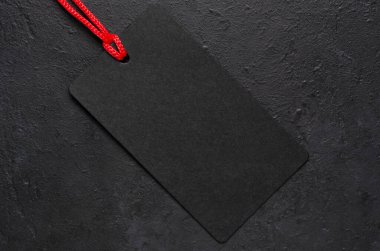 Siyah etiket sallanıyor. Koyu beton arka plan. Kara Cuma 'da tatil satışları fikri. Boşluğu kopyala.