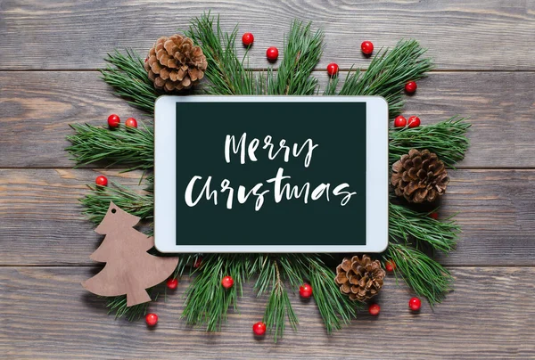 Ahşap bir arka planda Noel ya da yeni yıl geçmişi. Cihaz ekranında elle yazılmış bir yazı var. Düz yatıyordu