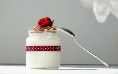 Şeffaf bir kavanozda çilek ve granola ile yoğurt