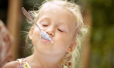 Sevimli kız çocuk bir co lezzetli bir dondurma ile bir kaşık yalar