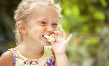 Sevimli küçük Kız renkli arka plan üzerinde Dondurma yeme