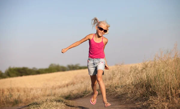 Happy Baby Girl z białymi włosami biegną wzdłuż pola pszenicy w — Zdjęcie stockowe