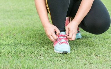 Runner onun ayakkabı bağcığı çim kadar bağlıyor. Egzersiz daha önce hazırlamak