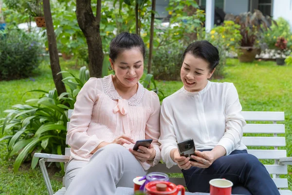 Két ázsiai középkorú nők, akik barátok keresik a p — Stock Fotó