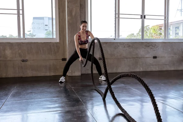 Schöne asiatische Mädchen ist schwingen das Seil in der gym.she smile happ — Stockfoto