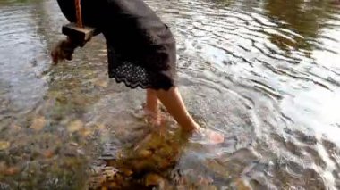 bir kadın akarsu boyunca bir salıncak üzerinde oturan yavaş ve mutlu bir rahatlatıcı bir gün su üzerinden ayaklar Swing.