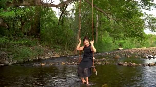 Женщина Сидящая Качелях Вдоль Ручья Качели Ваши Ноги Через Воду — стоковое видео