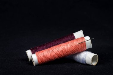 Siyah arka planda iğne ve iplik.