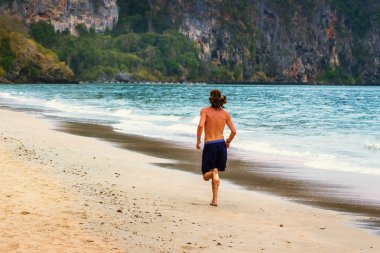 genç adam sahilde koşu.