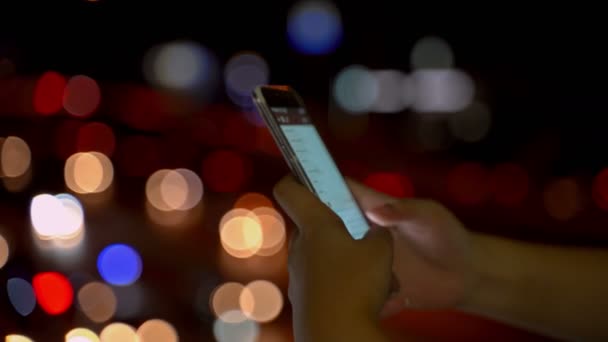 4K特写 女性手在夜间在街边使用智能手机 搜索或社交网络概念 时髦的男人打短信给他的朋友 青少年使用社交媒体 — 图库视频影像