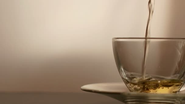ドリーショット お茶注ぐ グラス透明ティーカップにお茶を注ぎます ティータイムだ透明なガラスティーポットとティーカップ — ストック動画
