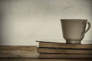 Eski kitaplar ile kahve Fincan, atmosfer yalnız hissediyorum