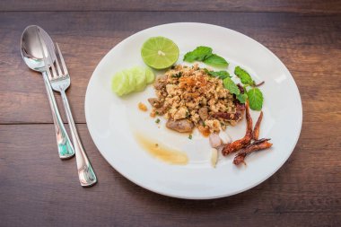 Ahşap zeminde baharatlı kıymalı tavuk salatası.