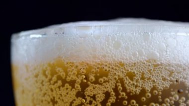 4K makro çekim, bardağın üzerine bira kabarcığı gelene kadar bardağa dök..