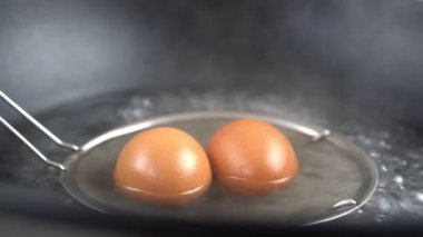 Kaynamış sudan haşlanmış yumurta alırken yavaş çekim. Makro çekimleri kapat