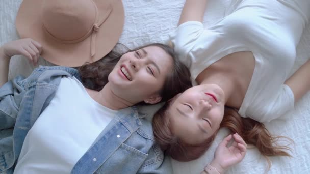 两个美丽的亚洲女孩是朋友 她们躺在床上聊天 心情很好 友谊概念 — 图库视频影像